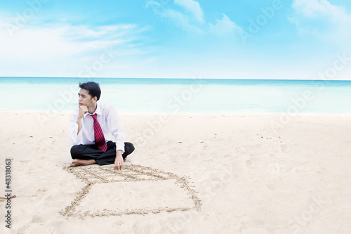 Photo: Businessman thinking on a beach Businessman thinking on a beach