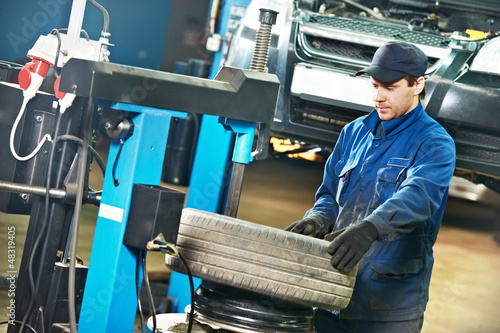 Photo: auto repairman at tyre replacement place auto repairman at tyre replacement place
