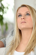Young woman at home looking at the ceiling