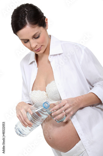 Photo: Pregnant woman holding bottle of water Pregnant woman holding bottle of water