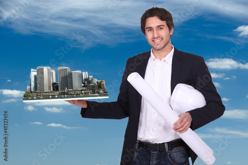 Photo: Engineer holding a model of a city Engineer holding a model of a city