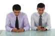 Businessmen sending text messages simultaneously