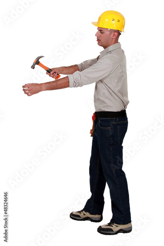 Photo: Man hammering an invisible object Man hammering an invisible object