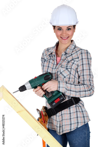Photo: Woman drilling into plank of wood Woman drilling into plank of wood