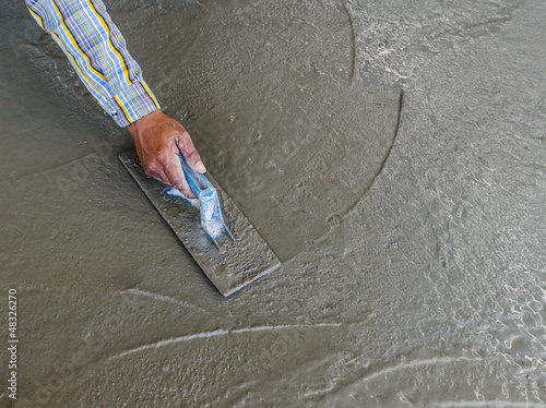 Photo: hand using trowel to finish wet concrete floor hand using trowel to finish wet concrete floor