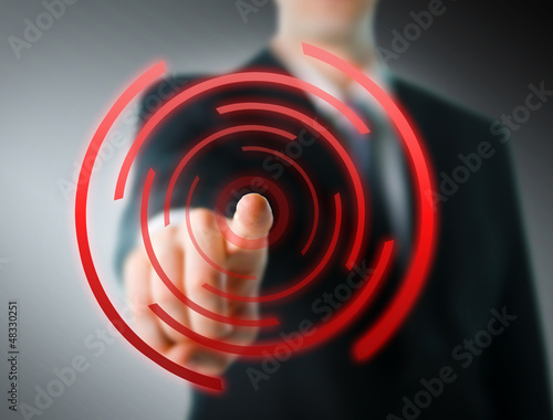 Photo: Businessman pointing at camera with digital elements Businessman pointing at camera with digital elements