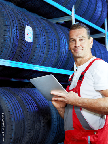 Photo: Master mechanic looking for the right tire with touchpad Master mechanic looking for the right tire with touchpad