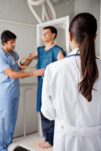Photo: Doctor With Technician Assisting Patient For X-ray Doctor With Technician Assisting Patient For X-ray