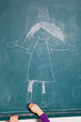 Child drawing picture on chalkboard