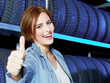 Female customer in garage shows thumb up for good service