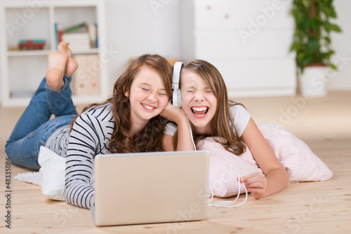 Photo: zwei freundinnen hören musik mit laptop zwei freundinnen hören musik mit laptop