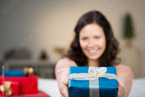 Photo: lächelnde frau überreicht ein weihnachtsgeschenk lächelnde frau überreicht ein weihnachtsgeschenk