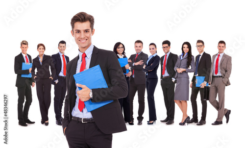 Photo: Leader holding a clipboard with business team behind Leader holding a clipboard with business team behind