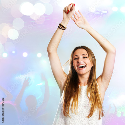 Photo: Young woman dancing with party background. Young woman dancing with party background.