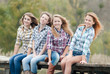 Photo: Four girls sitting on river bridge Four girls sitting on river bridge