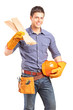 A smiling carpenter holding a helmet and sills