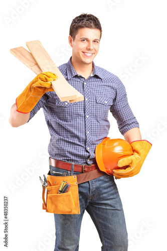 Photo: A smiling carpenter holding a helmet and sills A smiling carpenter holding a helmet and sills