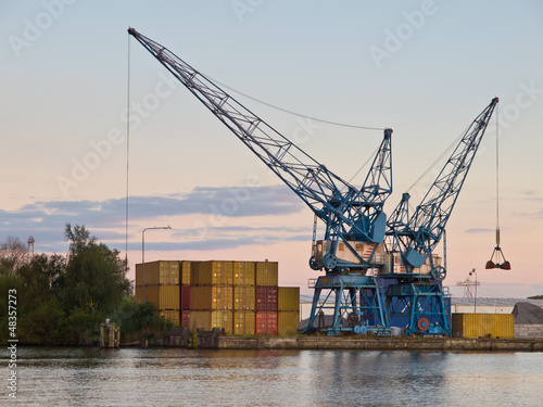 Photo: Two cranes are waiting for cargo in a dutch harbour Two cranes are waiting for cargo in a dutch harbour