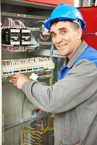 Photo: Happy electrician working at power line box Happy electrician working at power line box