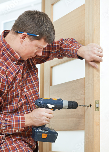 Photo: carpenter at door lock installation carpenter at door lock installation