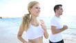 Young couple jogging on the beach in morning time