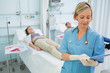 Nurse standing while looking at a clipboard