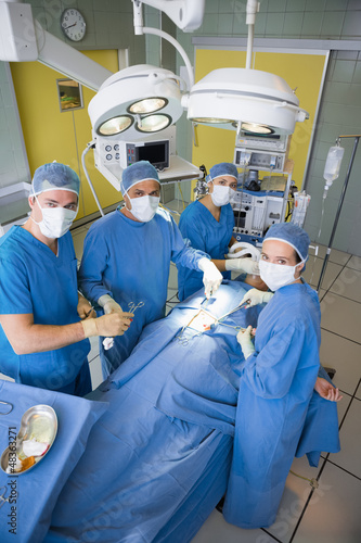 Photo: Surgery team looking at camera during operation Surgery team looking at camera during operation