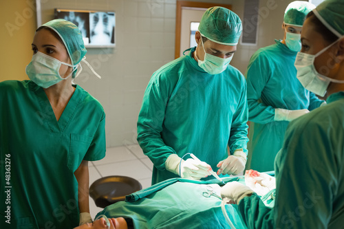 Photo: Team of surgeons working on the stomach of a patient Team of surgeons working on the stomach of a patient