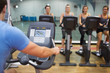 Man teaches spinning class to happy women