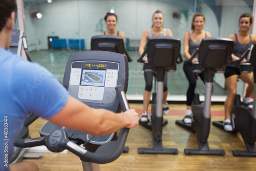 Photo: Man teaches spinning class to happy women Man teaches spinning class to happy women