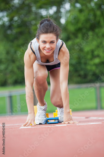 Photo: Female athlete at starting blocks Female athlete at starting blocks