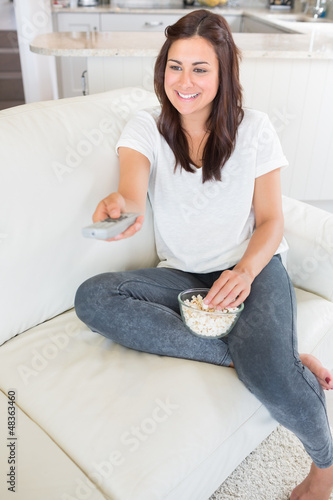 Photo: Woman watching tv and eating popcorn Woman watching tv and eating popcorn