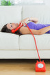 Happy woman using her land line and lying on sofa