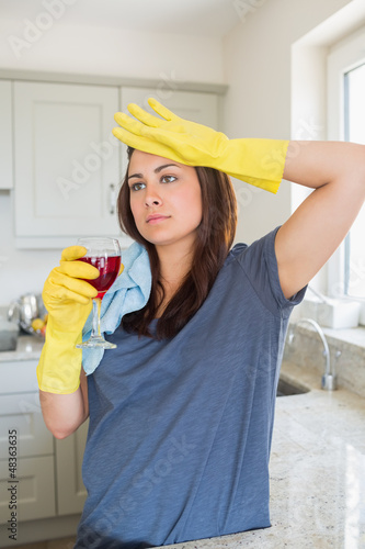 Photo: Woman drinking glass of wine after housework Woman drinking glass of wine after housework