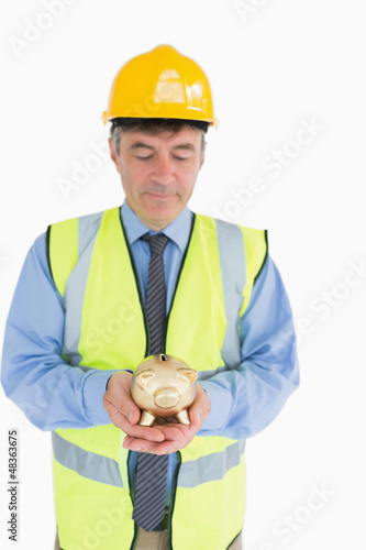 Photo: Architect holding a piggy bank Architect holding a piggy bank