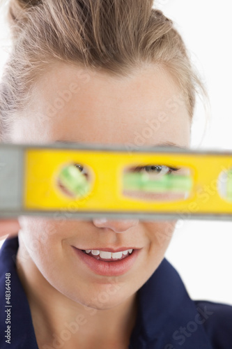 Photo: Young female technician with spirit level Young female technician with spirit level