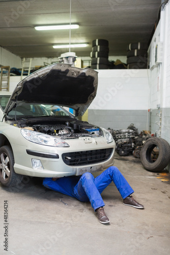 Photo: Auto mechanic working under car Auto mechanic working under car
