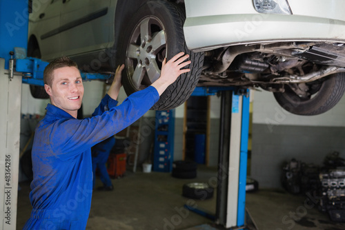 Photo: Auto mechanic adjusting car tire Auto mechanic adjusting car tire
