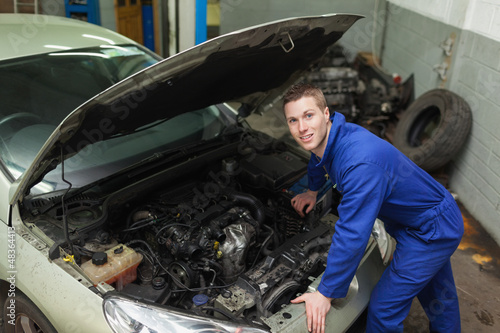 Photo: Mechanic by car with open hood Mechanic by car with open hood