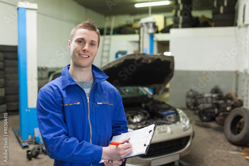 Photo: Mechanic writing on clipboard Mechanic writing on clipboard