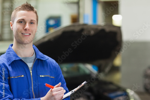 Photo: Happy mechanic with clipboard Happy mechanic with clipboard
