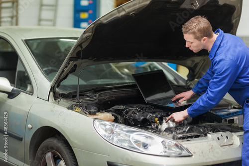 Photo: Mechanic with laptop checking engine Mechanic with laptop checking engine