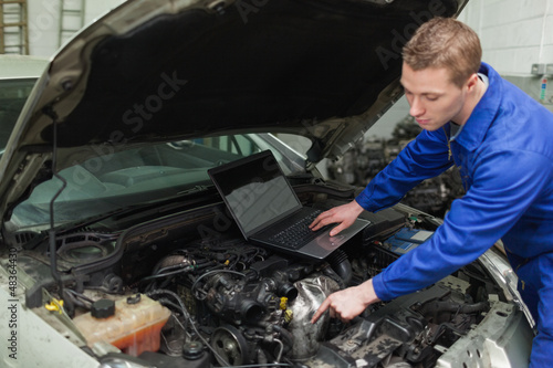Photo: Mechanic with laptop repairing car Mechanic with laptop repairing car
