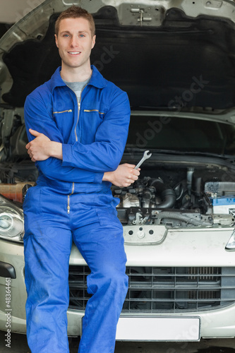 Photo: Happy mechanic leaning on breakdown car Happy mechanic leaning on breakdown car