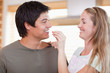 Woman feeding vegetable to man