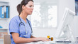 Female surgeon using computer at clinic