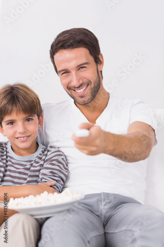 Photo: Smiling father and son watching tv Smiling father and son watching tv