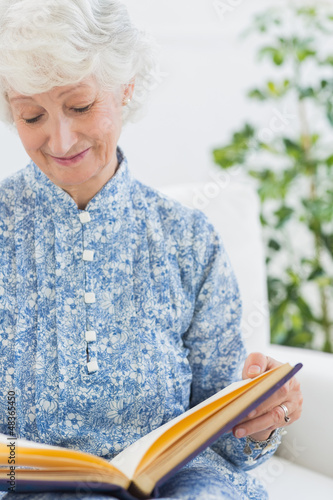 Photo: Elderly woman looking at her album Elderly woman looking at her album