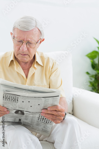 Photo: Focused elderly man reading the news Focused elderly man reading the news