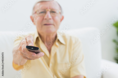 Photo: Concentrated elderly man using the remote Concentrated elderly man using the remote